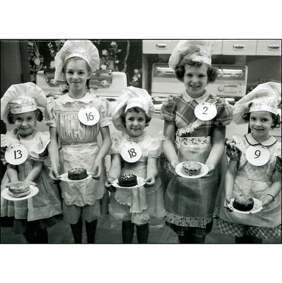 The front of the card shows  five young bakers wearing baker's hats and presenting their baking efforts.